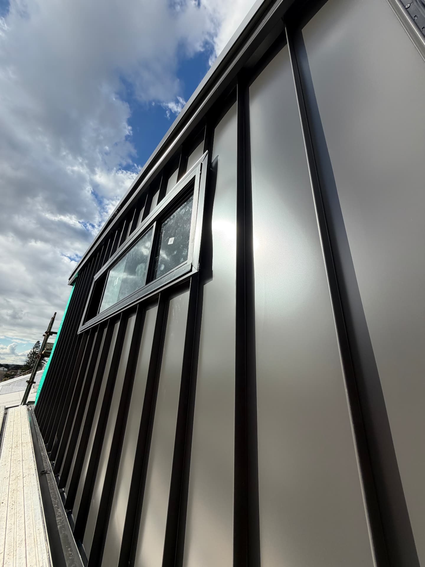 Architectural metal wall cladding with concealed fixings and a window reveal, installed by Marvel Roofing Projects in Sydney